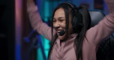 Genç bir kız bilgisayarda oyunlar oynuyor. Profesyonel oyuncu internet şampiyonluğu raundunu kazanıyor. Kadın ellerini havaya kaldırıyor ve takım üyelerine neşeyle bağırıyor.