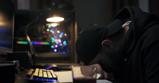 Estudiante mientras estudiaba para los exámenes se quedó dormido por la noche en el escritorio con una taza de café, un hombre se despierta mirando a su alrededor confundido frotando los ojos, un científico de la computación mira a la computadora — Vídeo de stock