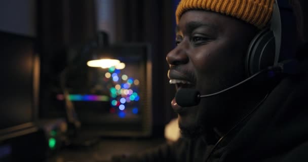 Ένας σοκαρισμένος άντρας παίζει ένα συναισθηματικό παιχνίδι στον υπολογιστή, ξαναζώντας τις σφαίρες, κάνοντας κλικ στα δάχτυλα του πληκτρολογίου, τα μάτια του κοιτάζουν την οθόνη, το δωμάτιο φωτισμένο από LED — Αρχείο Βίντεο