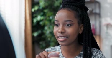 Yüzük ışığının arkasından, Afro-Amerikan kökenli esmer bir kadının yüzüne yakın çekim yapan makyöz, kendisine estetik tavsiyelerde bulunduğu hayranlarıyla konuşuyor ve kullandığı temel fırçaları anlatıyor.