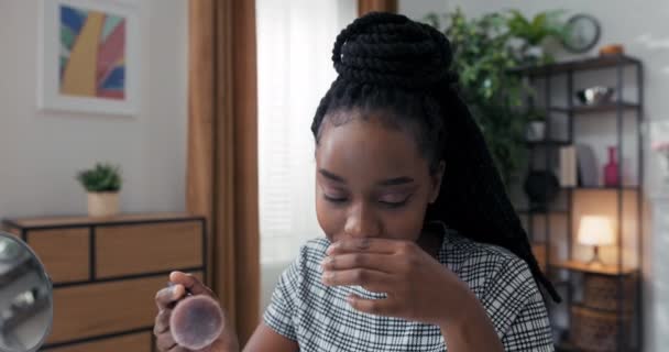 Primer plano del maquillador realizando una prueba en vivo del producto de marca cosmética frente a la audiencia de las redes sociales. Chica está probando arroz en polvo y aplicándolo a la cara con cepillo mientras se mira en el espejo — Vídeos de Stock