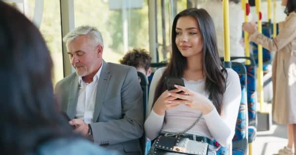 Piękna brunetka dziewczyna trzyma telefon i przeglądanie social media student w drodze powrotnej z — Wideo stockowe