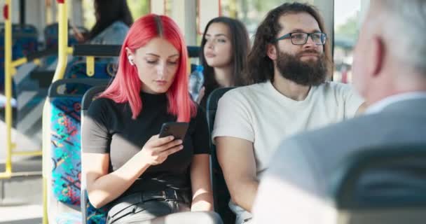 Femme aux cheveux roses monte bus de transport en commun, fille utilise smartphone, a sans fil dans les écouteurs, — Video