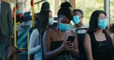 Saçları topuz gibi bağlanmış ve yüzünde koruyucu maske olan güzel bir kadın.