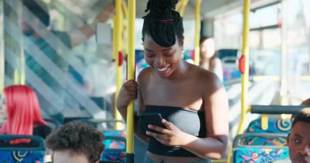 Dark-skinned beautiful woman with dreadlocks tied up in a bun stands on a public transport — ストック動画