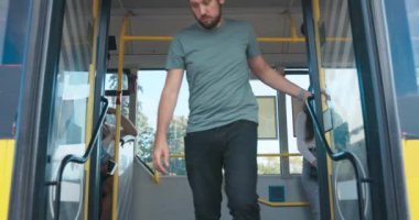 Durduktan sonra bir toplu taşıma aracının kapıları açılır. Bir adam.