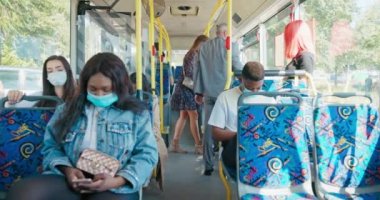 İnsanlar otobüs durağından otobüse biniyor. Yaşlı bir adam yardım eder.