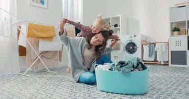 Çamaşırhanede kadın çamaşırları katlarken küçük bir çocuk annesiyle oynamak istiyor. Sevimli, güzel bir kız bebek annesinin sırtına biner, ona sarılır, annesi kızının kollarını bir uçak gibi açar.