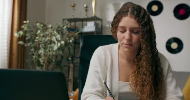 Meisje Met Krullend Haar Zit Aan Het Bureau Woonkamer Studies — Stockvideo