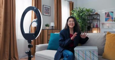 Kadın alışverişi kayıt ediyor. Kız giyim mağazasından sipariş edilen paketi açar. Mutlu nüfuzlu kız kutunun içine bakmaktan hoşlanıyor. Sosyal medya değerlendirmeleri, reklamcılık, ücretli işbirliği.