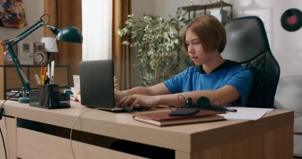 Genç Bir Çocuk Masadaki Bir Sandalyede Otururken Dizüstü Bilgisayar Kullanır — Stok video