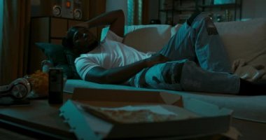 Üzgün, yaralı genç adam geceleri oturma odasında uzanıyor, uyuyamıyor, düşünemiyor, pencereden içeri giren sokak lambasıyla aydınlatılıyor. Çocuğun kalbi kırık, pizza yiyor ve sinirden patates kızartması yiyor..