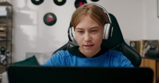 Teenager Benutzt Laptop Textet Freunde Hört Musik Über Drahtlose Kopfhörer — Stockvideo