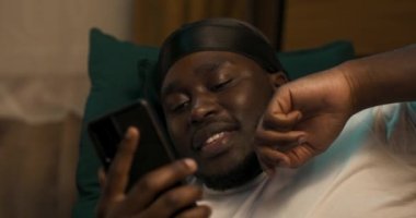 Oturma odasındaki kanepede uzanmış, telefonla konuşan, arkadaşlarıyla konuşan, video sohbeti yapan, dedikodu yapan adamların yakın plan fotoğrafları..