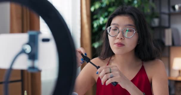 一个在美容业有经验的女孩用电话在社交媒体上拍摄了一个视频 有影响力的人展示睫毛膏 描述产品的好处 详细展示刷子 — 图库视频影像
