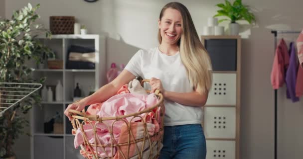 在家里干活的女人的画像 女孩子拿着柳条筐 里面装着洗衣服 装洗衣机 把湿衣服挂在烘干机上 料理家务的衣服 — 图库视频影像