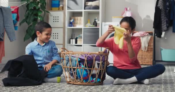 Broers Zussen Zitten Vloer Van Wasruimte Gekleurde Kleren Sorteren Voordat — Stockvideo