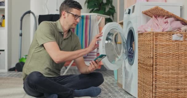 Handsome Smiling Young Man Jeans Shirt Sits Front Washing Machine — Video