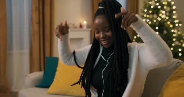 Zimowy Wieczór Afroamerykańska Dziewczyna Siedzi Kanapie Słucha Muzyki Sobie Czarne — Wideo stockowe