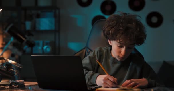 Junge Lernt Fleißig Vor Laptop Notizen Mit Bleistift Notizbuch Schreibt — Stockvideo