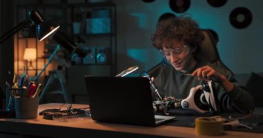 Çocuk, odasındaki masada dizüstü bilgisayarında eğitici videolar izliyor, video yapımcılarını ve lehim robotlarını tek başına taklit ediyor, kabloları bağlıyor, oyuncak elektrik sistemi yaratıyor..