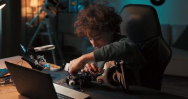 Gülümseyen bir çocuğun portresi, yetenekli zeki öğrenci okul yarışması için bir robot hazırlıyor, vidalıyor, sıfırdan bir oyuncak birleştiriyor..