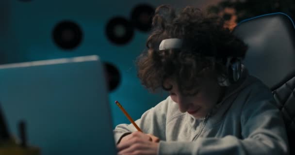 Boy Curly Hair Sits Room Desk Laptop Wireless Headphones Taking — Stok video