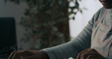 Ofiste oturan gülümseyen genç kadın cep telefonuyla konuşan dizüstü bilgisayara bakıyor. Kız güvenle bir müşteriyle görüşüyor. Evrak işlerini hallediyor..