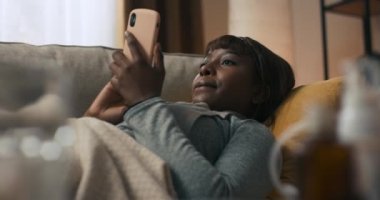 Genç bir kadın akıllı telefonuyla popüler web sitelerine girip online alışveriş yapma fırsatına odaklanmış durumda. Kız evden çıkmadan alışveriş yapabildiği için mutlu. İnternetten alışveriş.