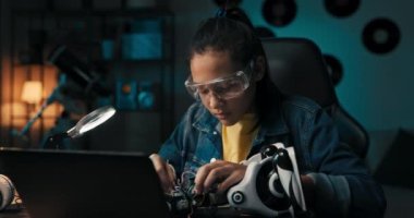 Mutlu genç kız robotik yetenekler geliştiriyor, elektrik oyuncaklarını tamir ediyor, kabloları, kabloları bağlıyor, okul projesi için kendi robotunu yapıyor..