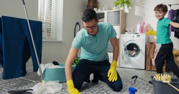 Pai Brinca Com Filho Lavandaria Enquanto Limpa Homem Está Segurando — Vídeo de Stock