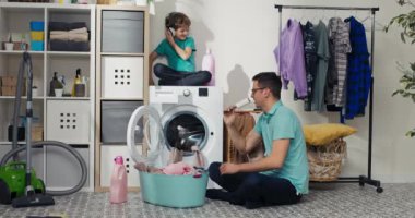 Babam çamaşırları yıkarken bebek çamaşır makinesine oturur. Çocuklar birlikte vakit geçirirken ev işleri yapıyorlar, aylaklık ediyorlar, şarkı söylüyorlar, müzik dinliyorlar..