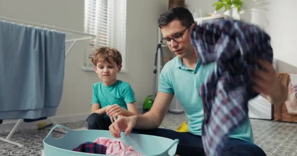 Smiling Father Son Sitting Laundry Room Floor Sorting Clothes Taking — Wideo stockowe