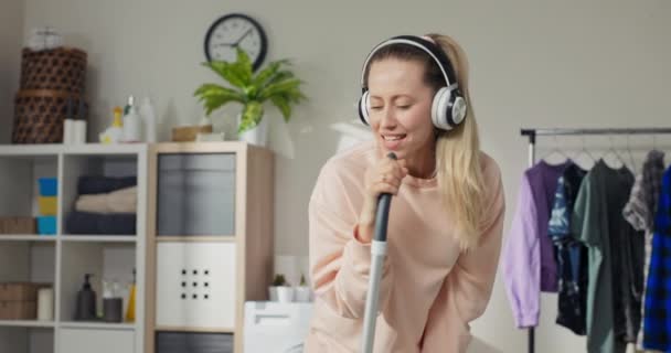 Mujer Joven Escucha Música Los Auriculares Inalámbricos Baila Mientras Que — Vídeos de Stock