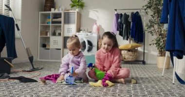 İki kız kardeş banyoyu, çamaşırhaneyi temizler ve yerleri deterjan ve paçavralarla paspaslar. Büyük kız, küçük kıza nasıl temizlik yapılacağını öğretiyor. Birlikte vakit geçiriyorlar. Anneye yardım ediyorlar..