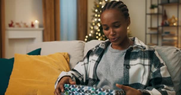 Winter Evening African Looking Girl Sits Sofa Living Room Unpacks — Stockvideo