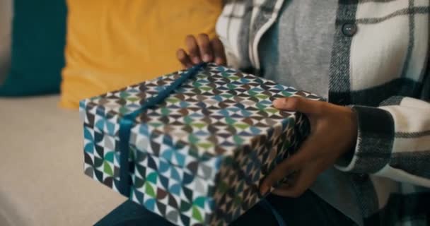 Winter Evening African Looking Girl Sits Sofa Unpacks Gift Untying — 비디오