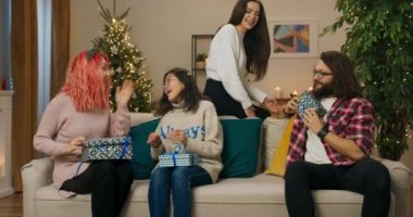 Sevgili öğrenciler üniversite Noel partisi için toplandılar. Arkadaşlar hediyelerini verir ve iletişim kurarlar. Kızlar kanepede oturuyor ve sarılıyorlar. Arkasında titreyen bir Noel ağacı.