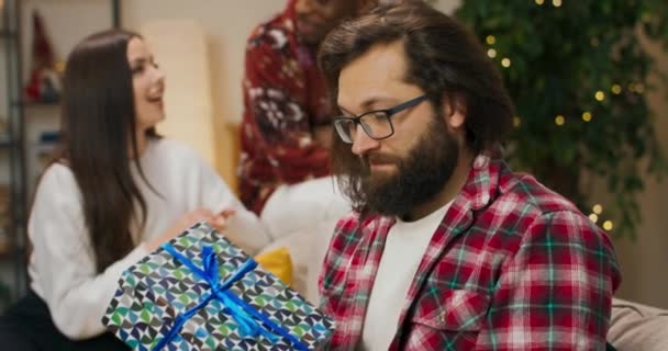 Atrakcyjny Młodzieniec Brodzie Okularach Trzymający Prezent Świąteczny Facet Nim Potrząsnął — Wideo stockowe