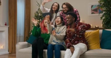 Noel partisi sırasında, arkadaşlar tatilde akrabalarını tebrik etmeye karar verdiler. Erkekler ve kızlar oturma odasındaki kanepede oturup görüntülü konuşma yaparlar. El sallarlar, gülümserler ve iletişim kurarlar..