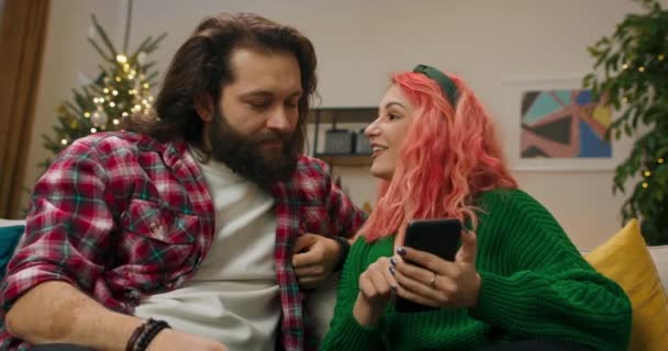 Christmas Eve Girl Red Curly Hair Guy Beard Sitting Sofa – Stock-video