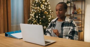 Afrikalı görünümlü bir kız oturma odasında masada oturuyor ve görüntülü konuşma yapıyor. Yeni ortaklarla iletişim kuruyor ve onlara projeden bahsediyor. Kızın elinde bir kağıt parçası var ve tüm detayları anlatıyor..