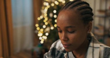 Kış akşamı. Odada bir Noel ağacı titriyor. Sınava hazırlanan ve ödev okuyan Afrikalı bir öğrencinin yakın çekimi. Kız metne odaklanıyor..