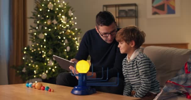 Otec Učí Dítě Během Vánočního Večera Recenzi Návod Hračky Tabletu — Stock video