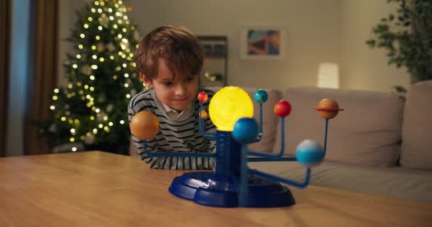 Egy Hétéves Fiú Tanulmányozza Bolygókat Előtte Asztalon Van Naprendszer Gyermekmodellje — Stock videók
