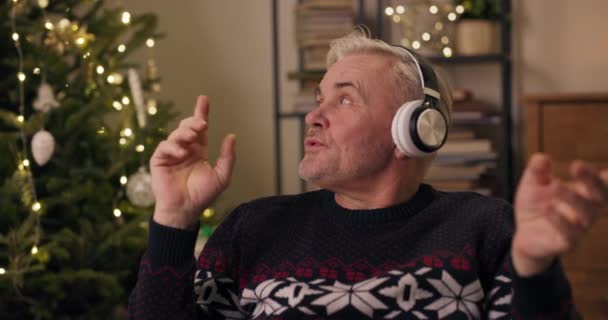 Attractive Happy Middle Aged Man Gray Hair Listens Christmas Carols — Stock Video