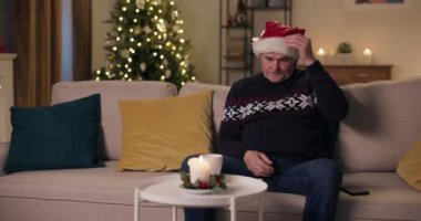 Noel arifesi. Oturma odasındaki koltukta oturan orta yaşlı yalnız bir adam. Hayal kırıklığına uğradı, Noel Baba şapkasını düşürdü ve bir kenara bıraktı. Bugün yalnız bırakıldı. O kalın bir kazak giyiyor..