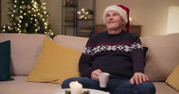 Homem Meia Idade Senta Sofá Segurando Uma Xícara Chá Olhando — Vídeo de Stock