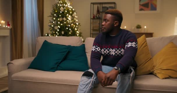 Attraktiver Junger Mann Afrikanischen Aussehens Der Auf Der Couch Sitzt — Stockvideo