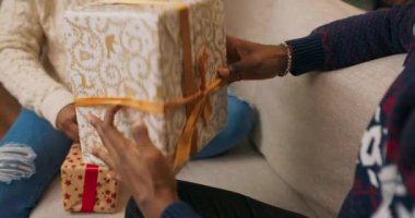 Noel 'e hazırlanan ve hediye paketleyen Afrikalı öğrencilerin yakın çekimi. Arkadaşlar kutuya kurdele bağlar ve iletişim kurarlar. Noel için akrabalarına seyahat etmeyi planlıyorlar..